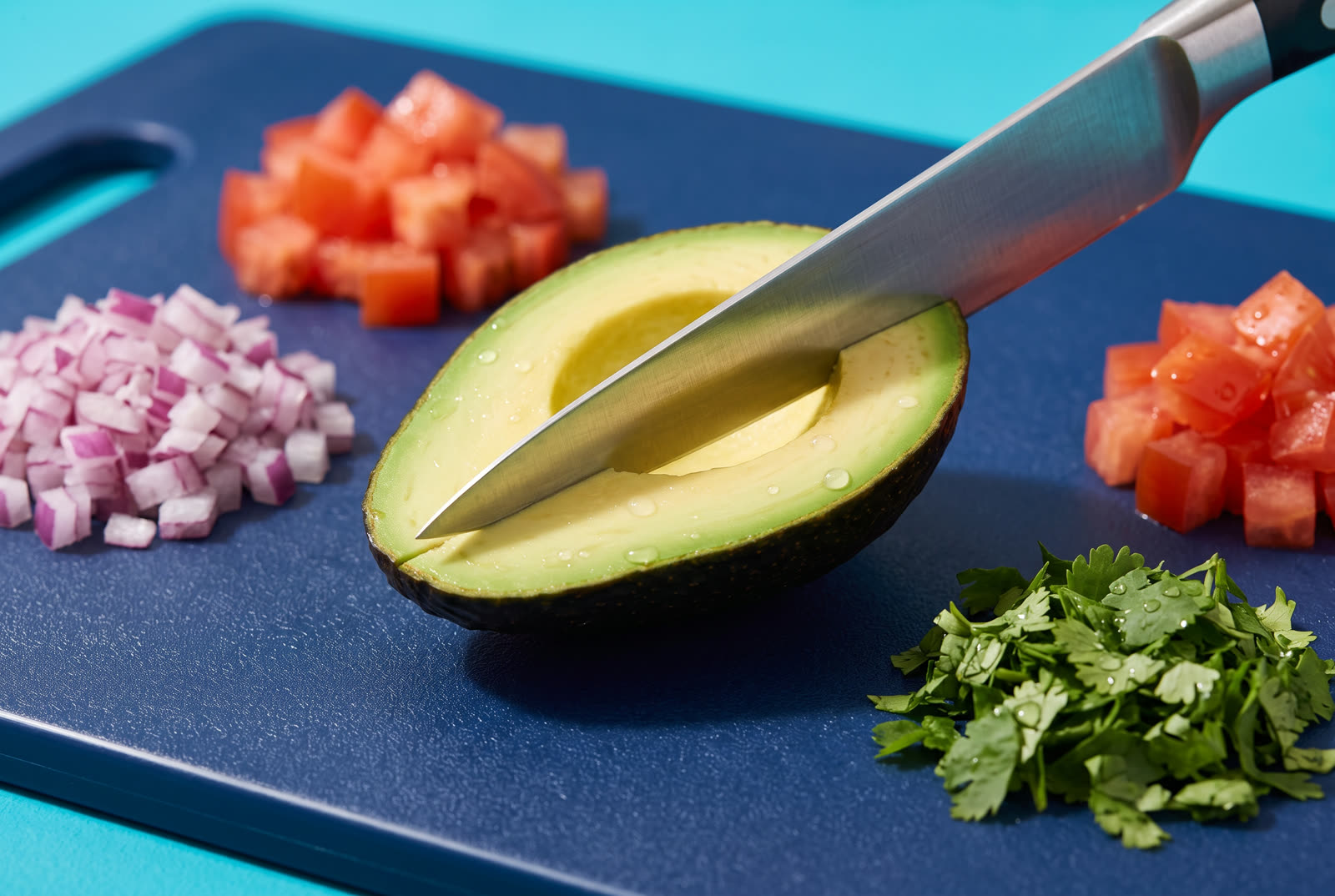 Tabla con aguacate, jitomate, cebolla y cilantro recién picados